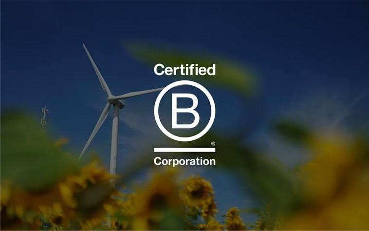 Certified B Corporation badge overlaid on a wind turbine photo, representing CnerG's environmental commitment.